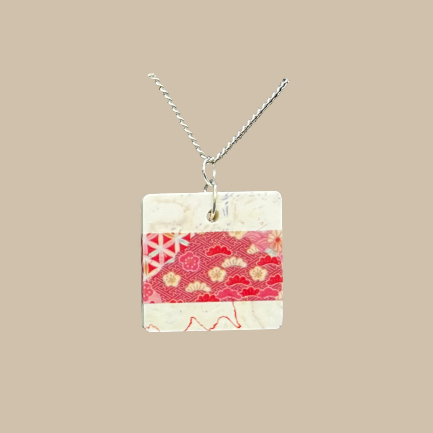 Unikt handgjort halsband med japanskt inspirerat mönster i röda och cremevita toner. Ett elegant och konstnärligt smycke i modern design.