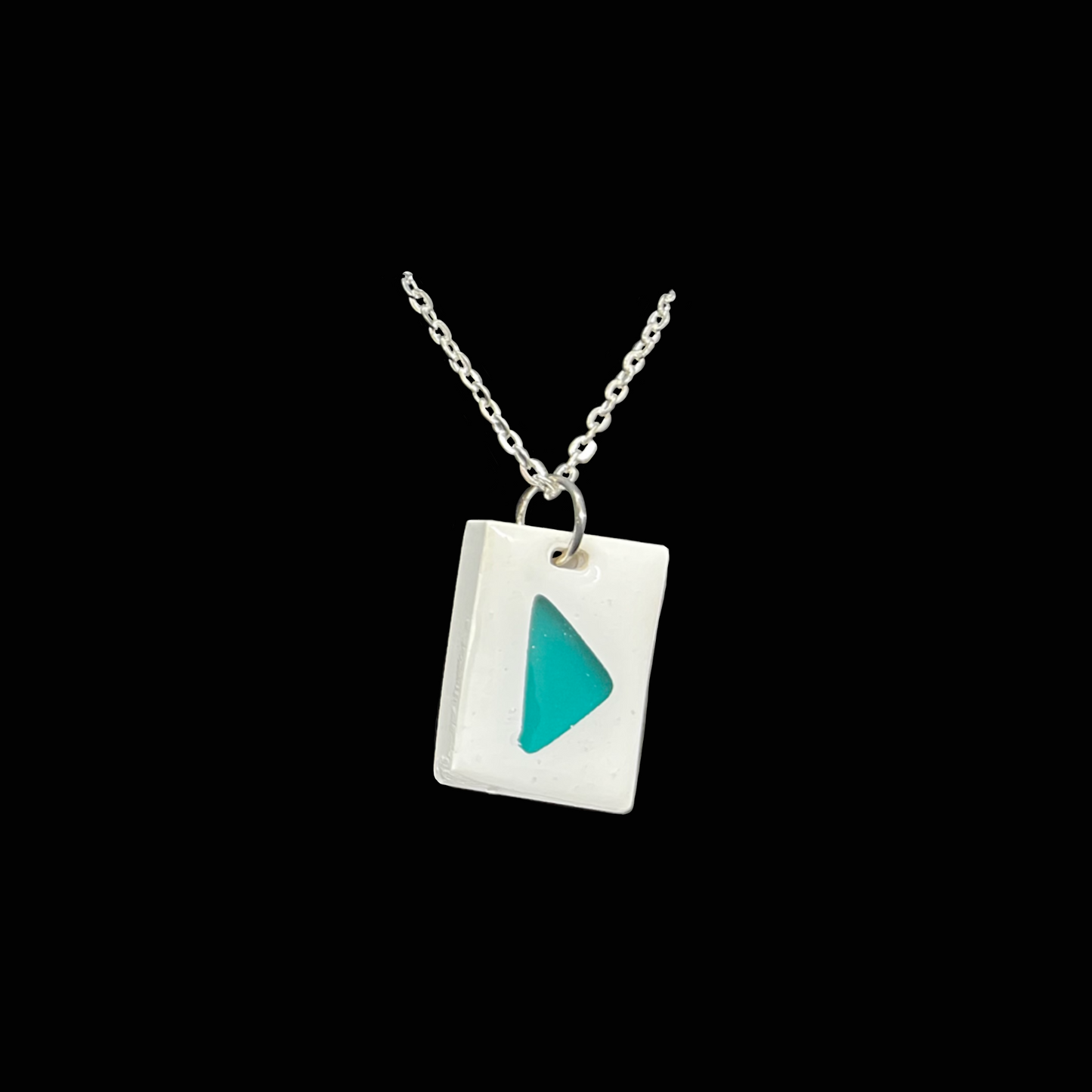 Unikt handgjort halsband med turkos detalj på vit bakgrund. Modernt och stilrent smycke i minimalistisk design.