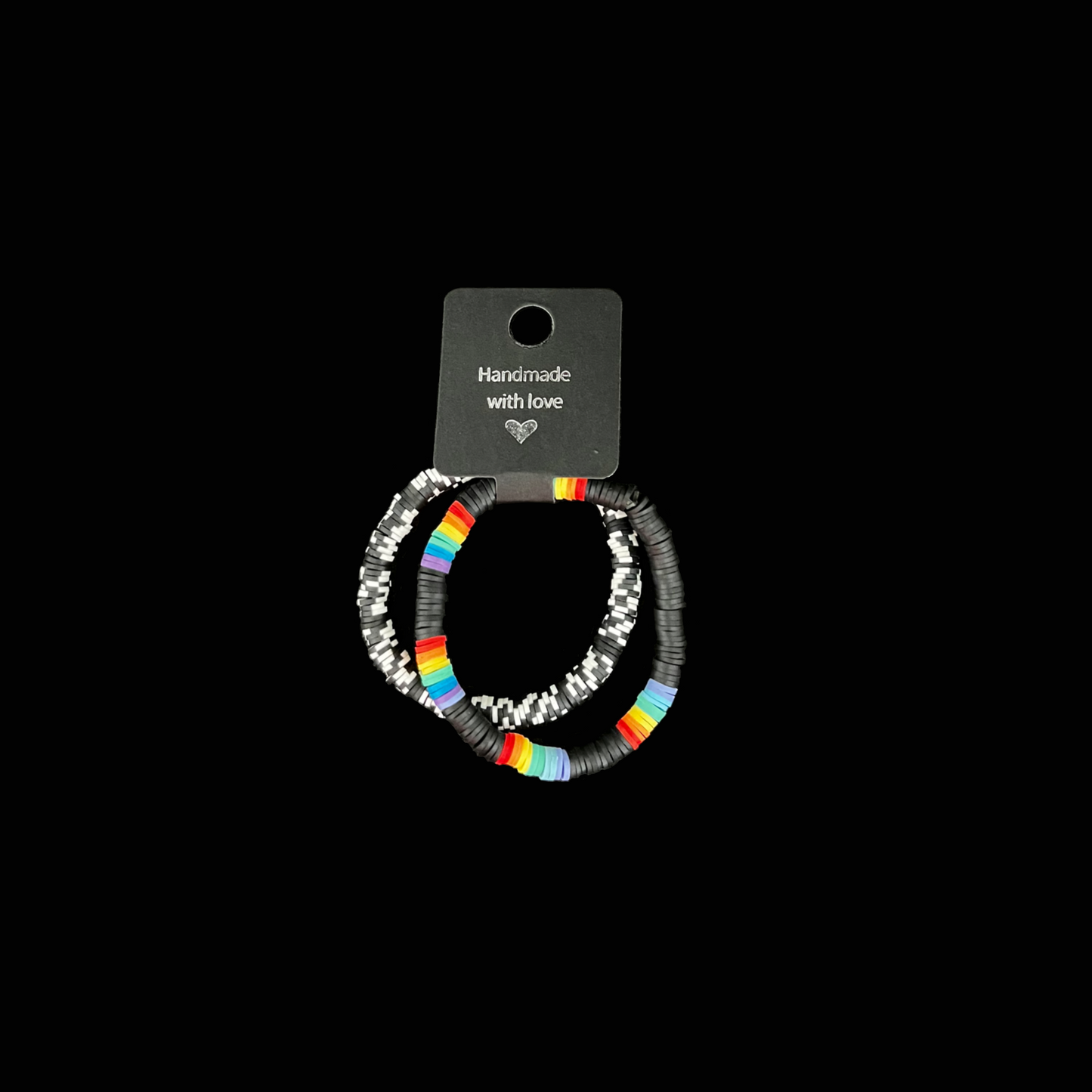Visa din stil med dessa två handgjorda armband i svart, vitt och regnbågsdetaljer. Den stilrena svarta basen lyfter fram de färgstarka inslagen.