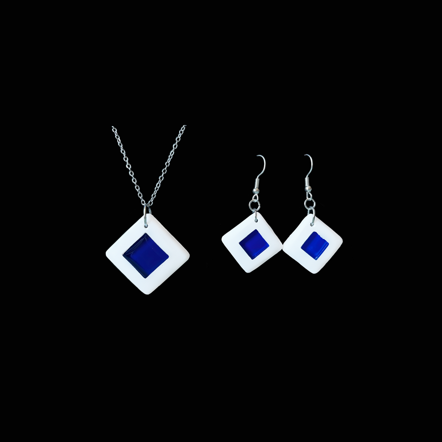 Ett elegant smyckeset (halsband och örhängen) i vitt och djupblått, där rena geometriska former möter modern minimalism.
