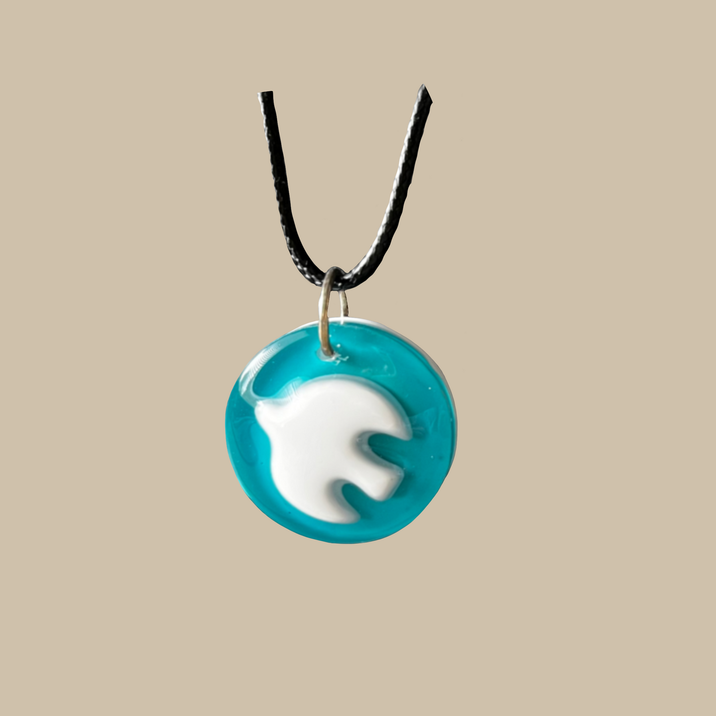 Handgjort halsband med vit fredsduva på turkos bakgrund. Ett unikt smycke som symboliserar fred, lugn och harmoni.