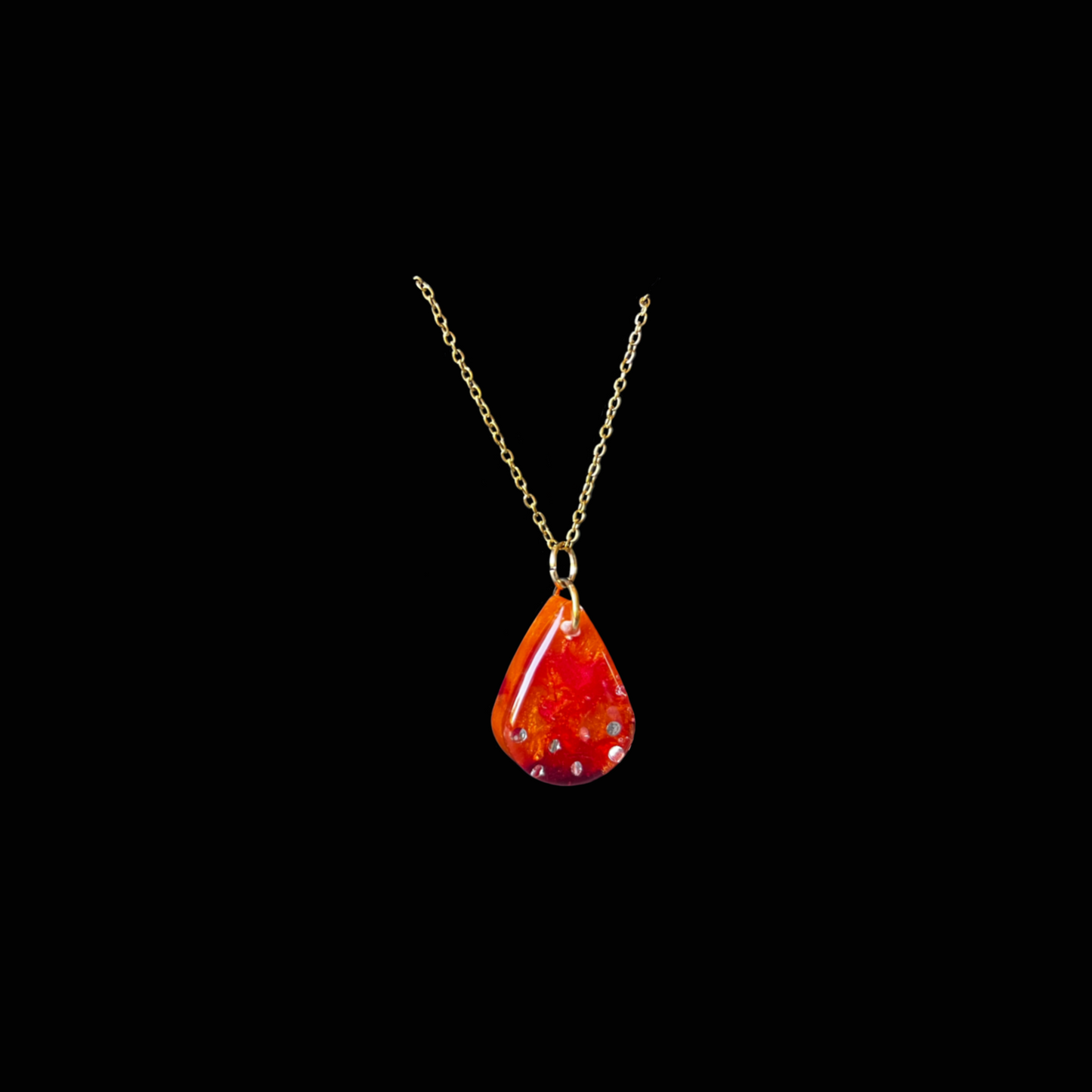 Handgjort droppformat halsband i resin med röd-orange glitter. Stilrent och färgstarkt smycke – unikt och tidlöst.