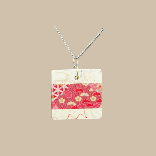 Unikt handgjort halsband med japanskt inspirerat mönster i röda och cremevita toner. Ett elegant och konstnärligt smycke i modern design.