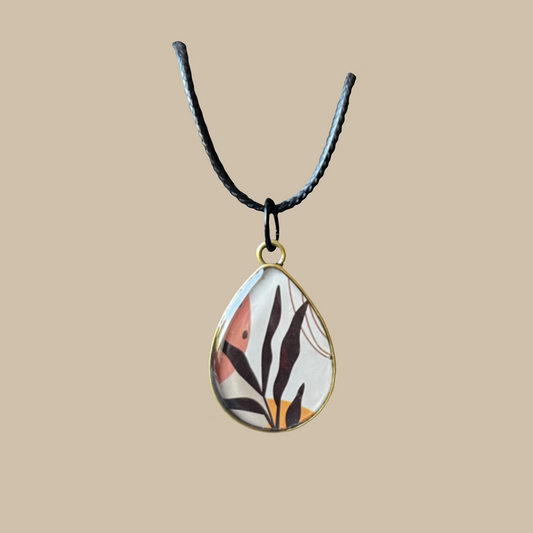 Unikt handgjort halsband i droppform med grafiskt naturinspirerat motiv i varma toner. Ett elegant och konstnärligt statement-smycke.