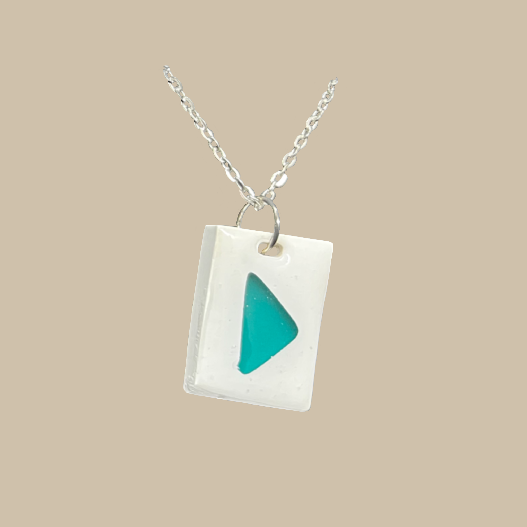 Unikt handgjort halsband med turkos detalj på vit bakgrund. Modernt och stilrent smycke i minimalistisk design.