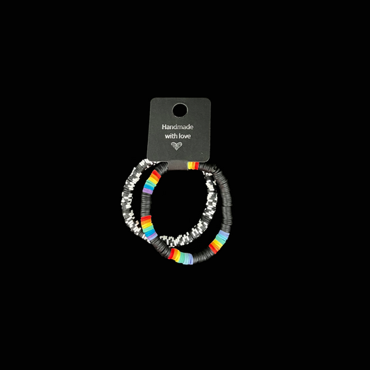 Visa din stil med dessa två handgjorda armband i svart, vitt och regnbågsdetaljer. Den stilrena svarta basen lyfter fram de färgstarka inslagen.