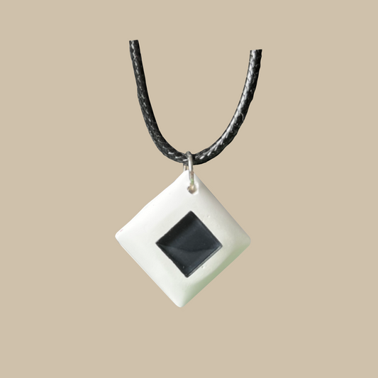 Unikt handgjort halsband i svart och vitt med grafisk diamantform. Ett stilrent statement-smycke i modern minimalistisk design.