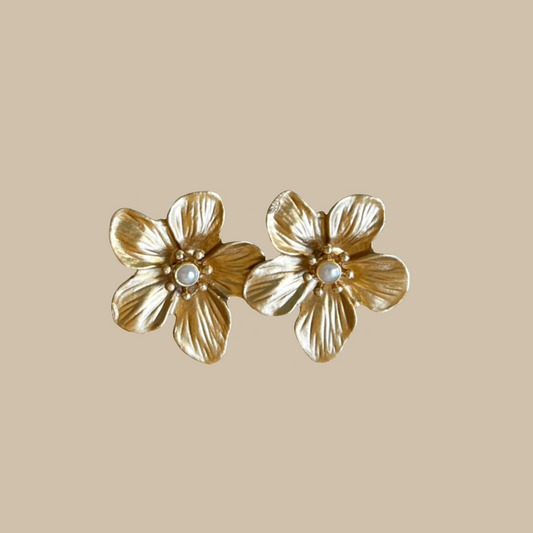 Eleganta örhängen i form av guldblommor med pärldetalj. Ett lyxigt smycke med romantisk och feminin känsla.