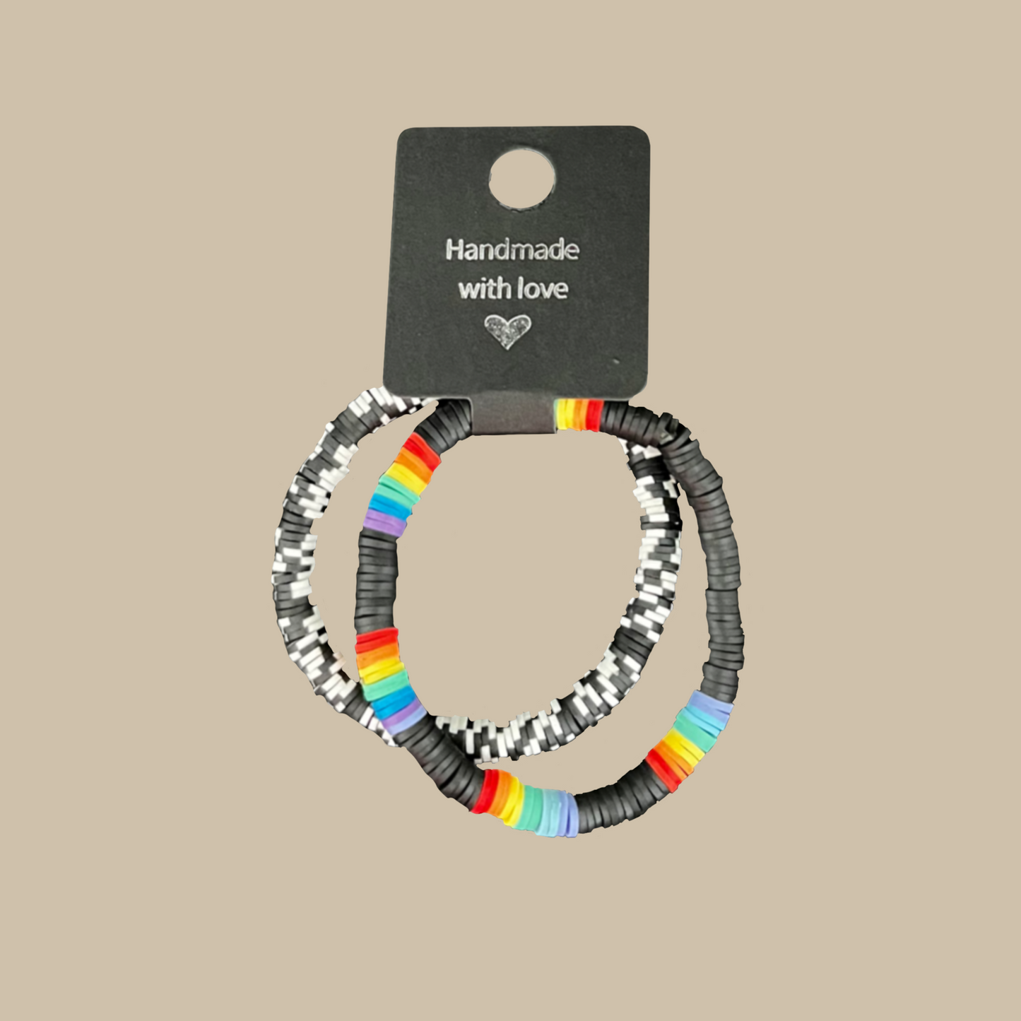 Visa din stil med dessa två handgjorda armband i svart, vitt och regnbågsdetaljer. Den stilrena svarta basen lyfter fram de färgstarka inslagen.