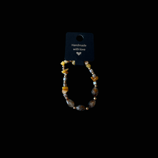 Golden Earth – handgjort armband i natursten från kollektionen Botanica – naturens poesi. Ett unikt exemplar med gyllene och jordnära toner, inspirerat av solens varma ljus.