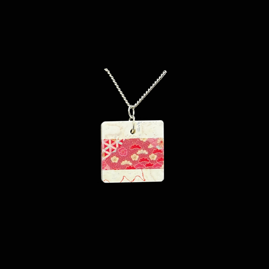 Ett unikt halsband som bär med sig känslan av japanska textilier och tidlös elegans. Det röda mönstret, med inslag av guld och geometriska former, påminner om en kimono i rörelse - vackert, stilrent och fyllt av kulturens djup. Bär Kimono när du vill addera en färgklick och historia till din outfit. 