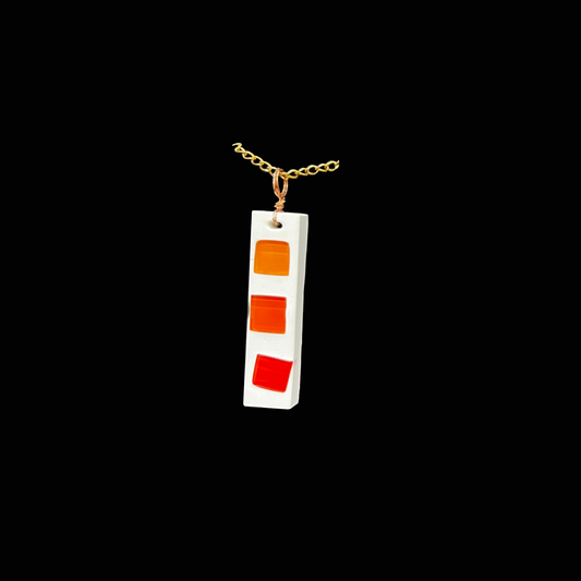 Ett färgstarkt halsband i rödorange toner som fångar både värme och energi. De glödande nyanserna i mosaiken påminner om solnedgång och sprakande eldar