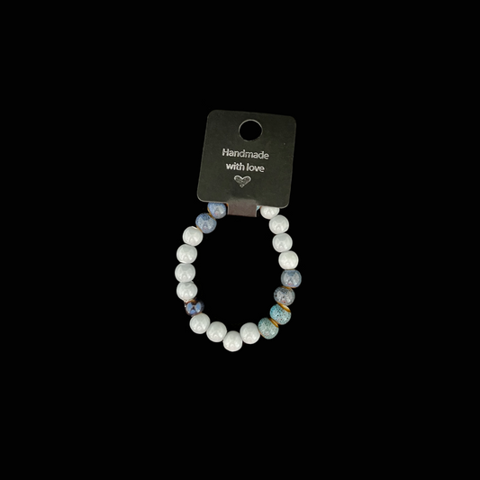 Handgjort armband i blå lavastenar och vita pärlor – inspirerat av havets färger.