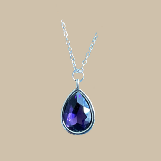 Handgjort halsband med skimrande lila droppe i elegant design. Ett unikt smycke i silverton med romantisk och mystisk känsla.