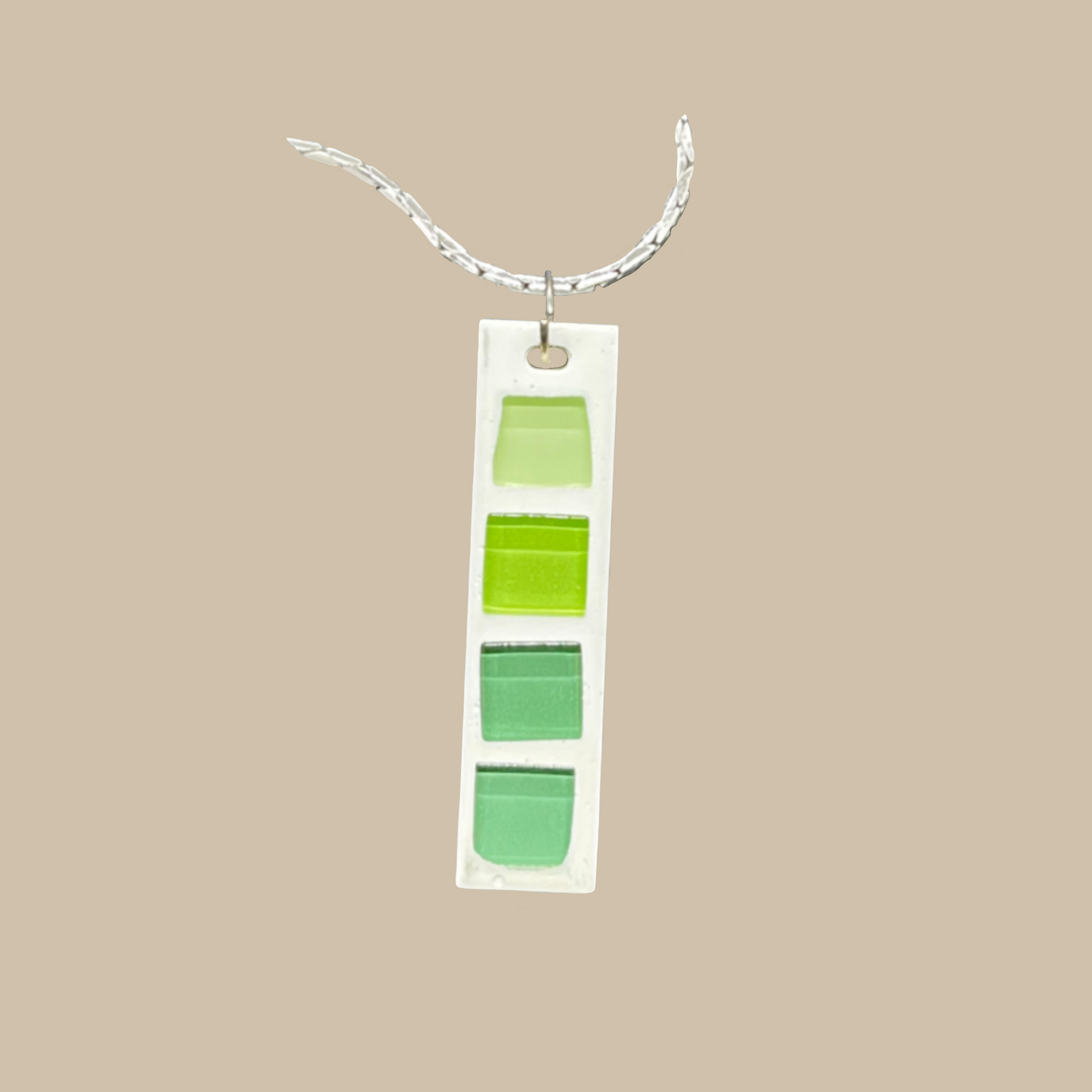 Limea är ett handgjort halsband i harts med grön glasmosaik. Grafiska och  modern minimalistisk design. Ett unikt statement-smycke från kollektionen Nordica