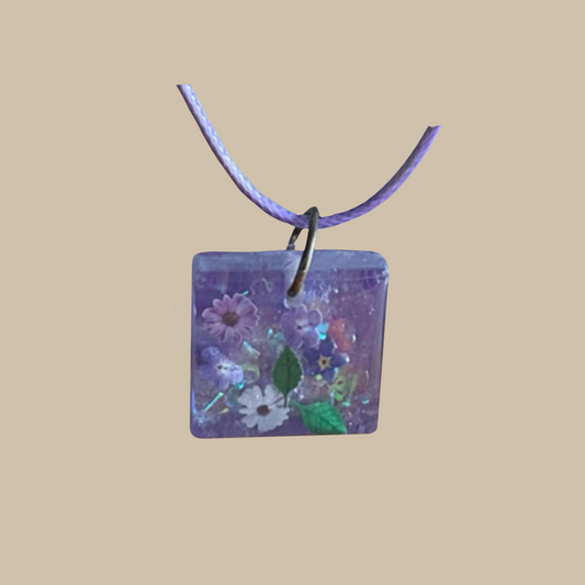 Unikt handgjort halsband i lila toner med små blommor och skimrande detaljer. Romantiskt och drömskt smycke.