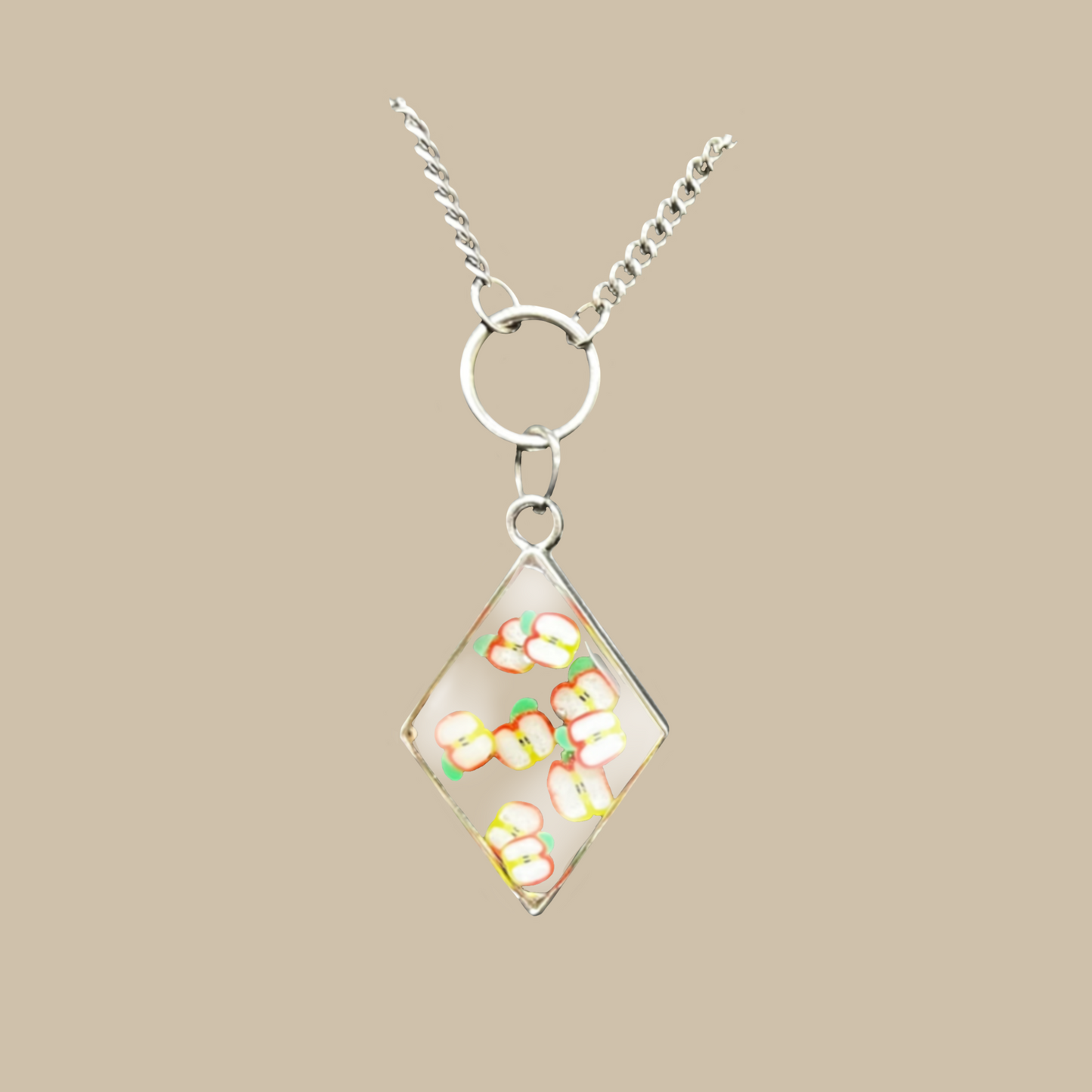 Unikt handgjort halsband med små äppelmotiv i transparent design. Ett lekfullt och modernt smycke fullt av färg och personlighet.
