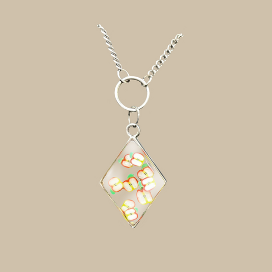 Unikt handgjort halsband med små äppelmotiv i transparent design. Ett lekfullt och modernt smycke fullt av färg och personlighet.