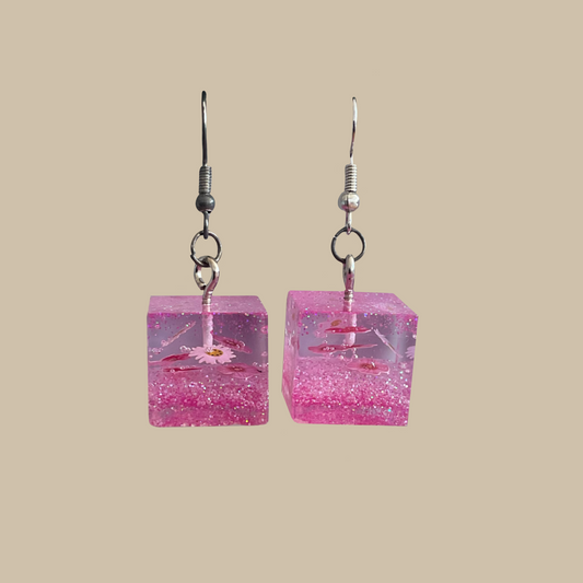 Handgjorda örhängen i rosa med glitter och små blommor. Lekfull och feminin design.