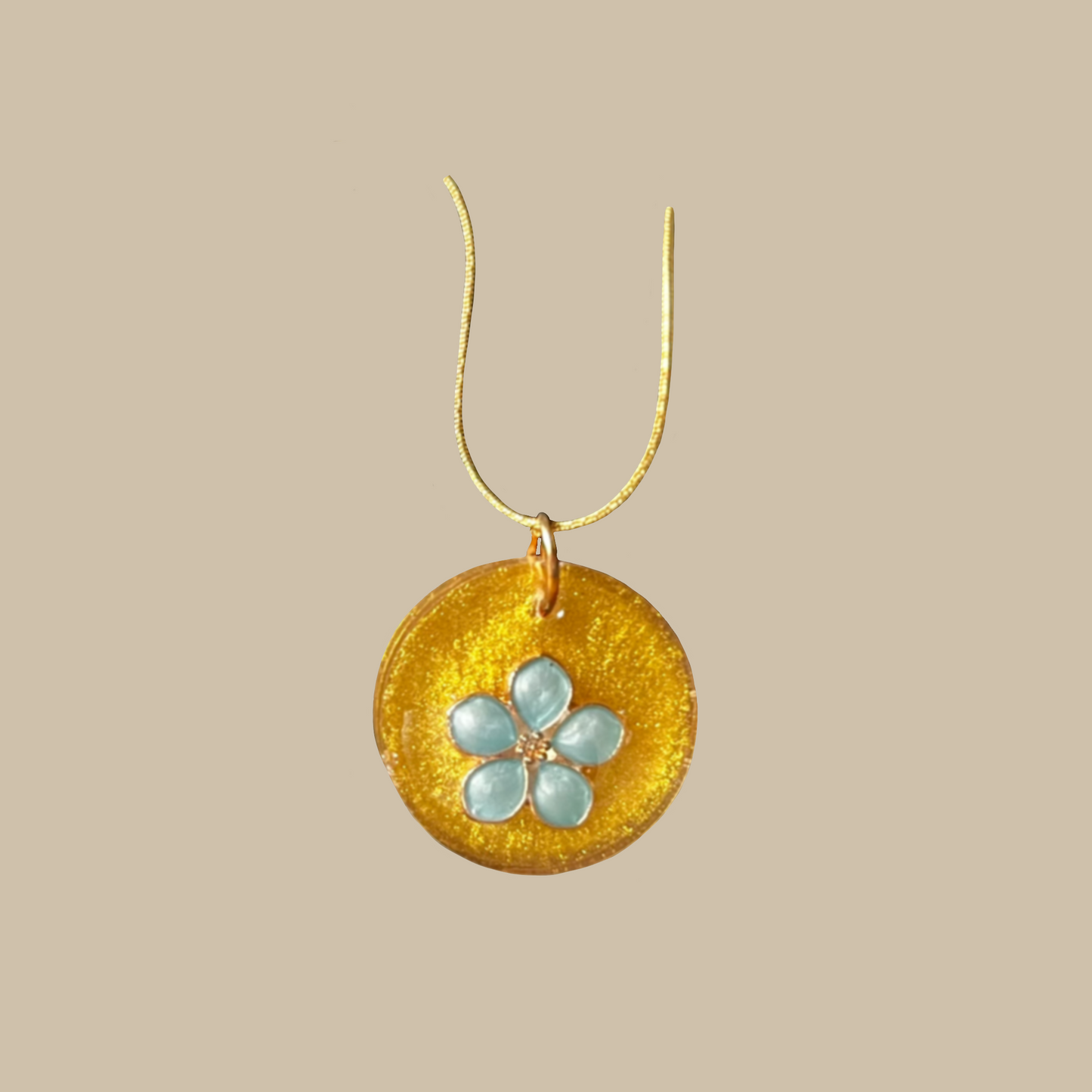 Unikt handgjort halsband med skimrande guldfärg och blomdetalj i ljusblå toner. Ett feminint och elegant smycke i ett enda exemplar.