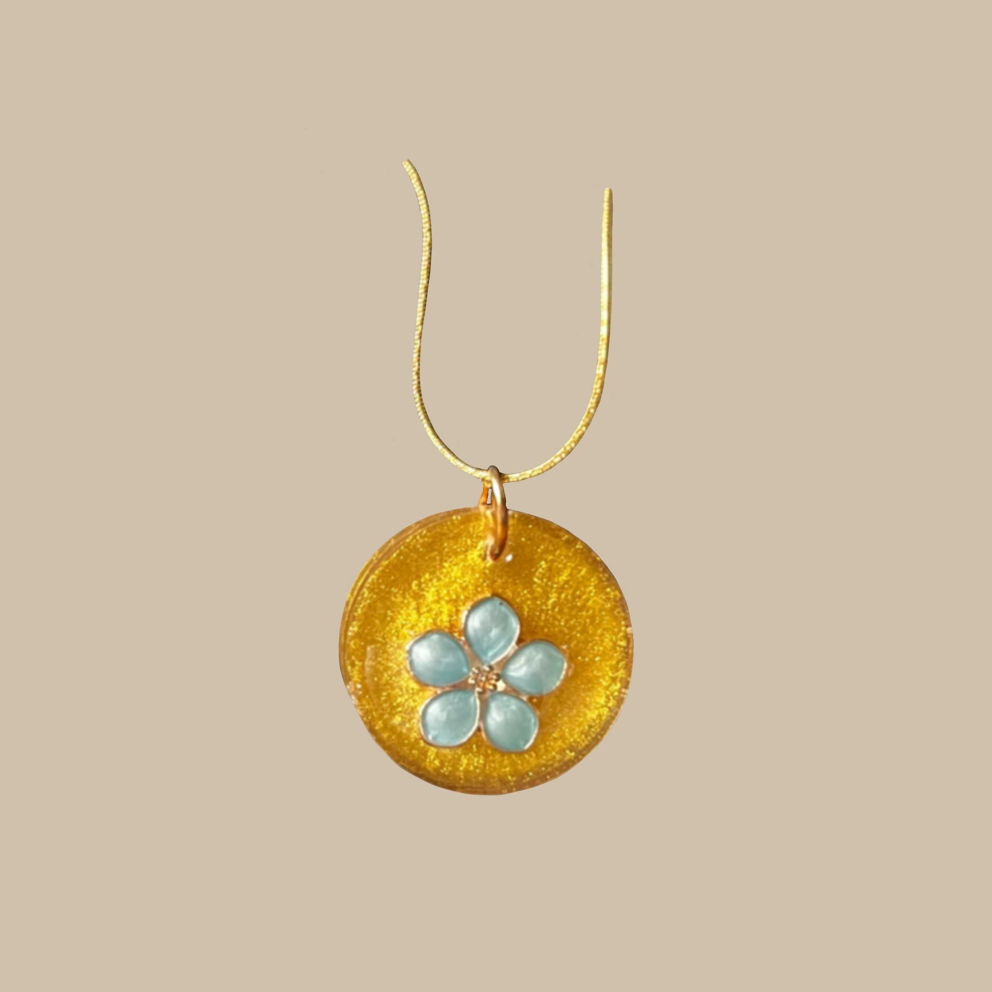 Unikt handgjort halsband med skimrande guldfärg och blomdetalj i ljusblå toner. Ett feminint och elegant smycke i ett enda exemplar.